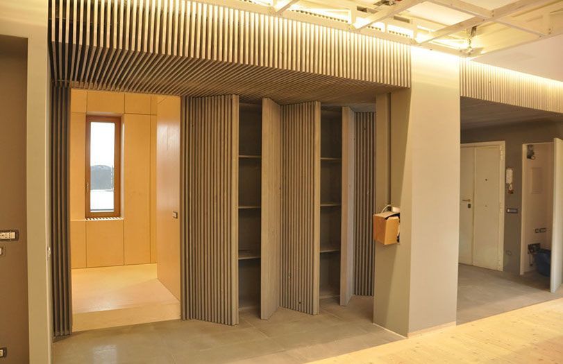 Bagno moderno con cabine beige e una piccola stanza, illuminata da calde luci dall'alto.