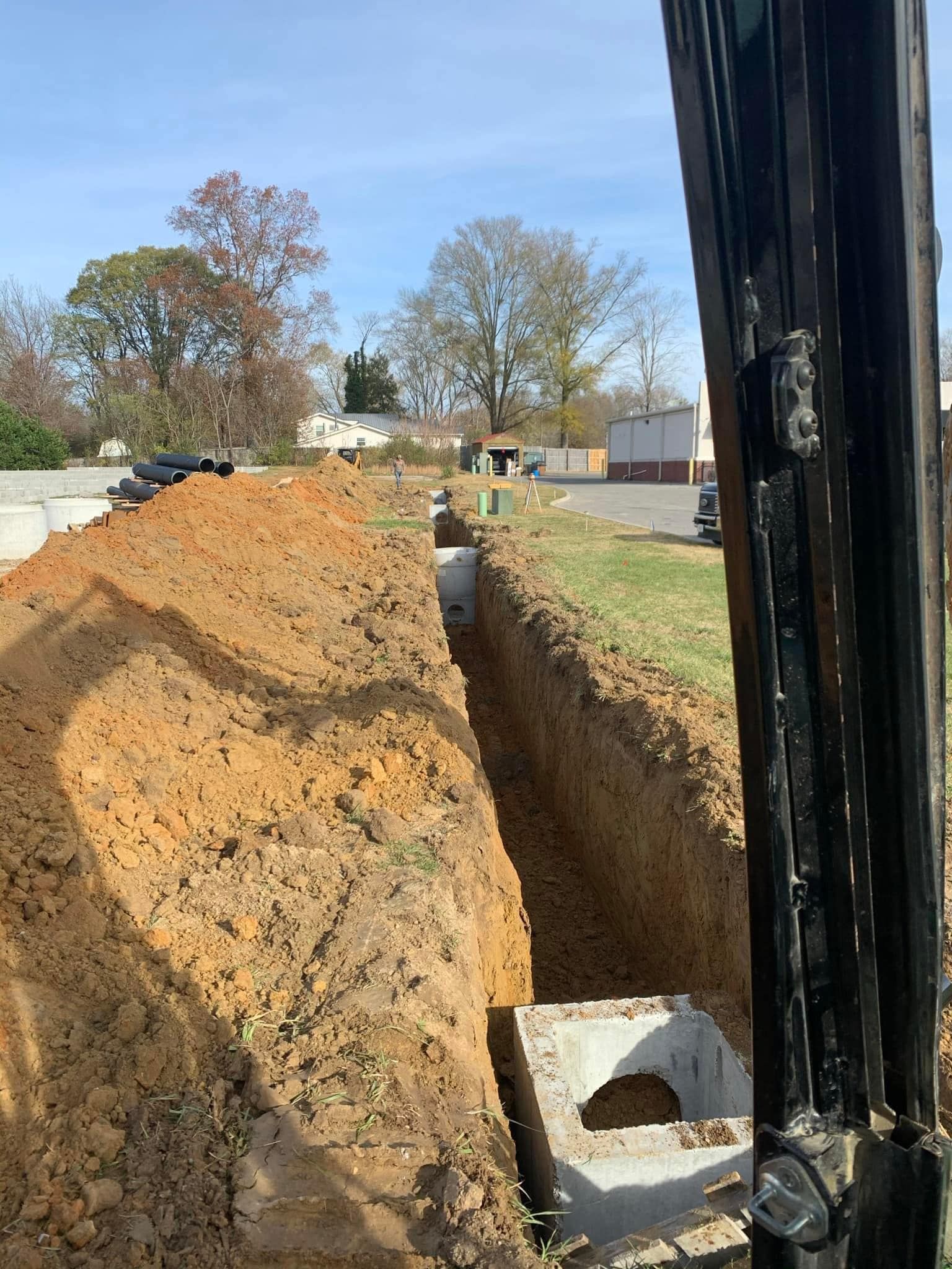 A large pile of dirt is sitting next to a forklift.