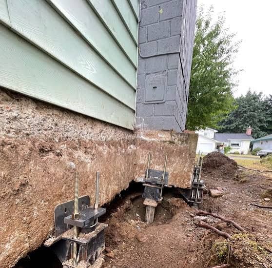 Hand trowel smoothing gray cement along a wall base outdoors