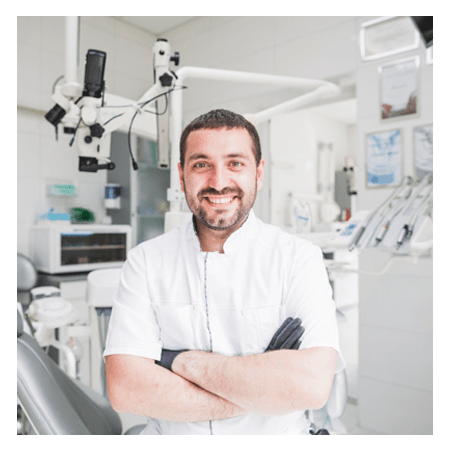 Dentista de braços cruzados olhando para a câmera
