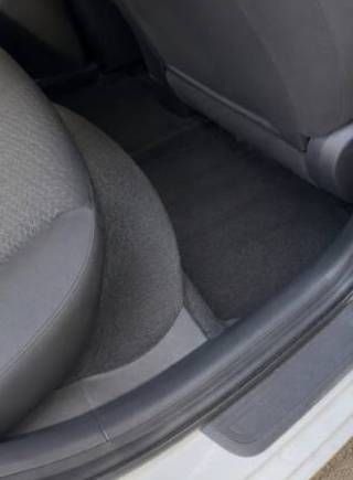 Gray car seats and black floor mat in a vehicle interior, with an open door threshold.