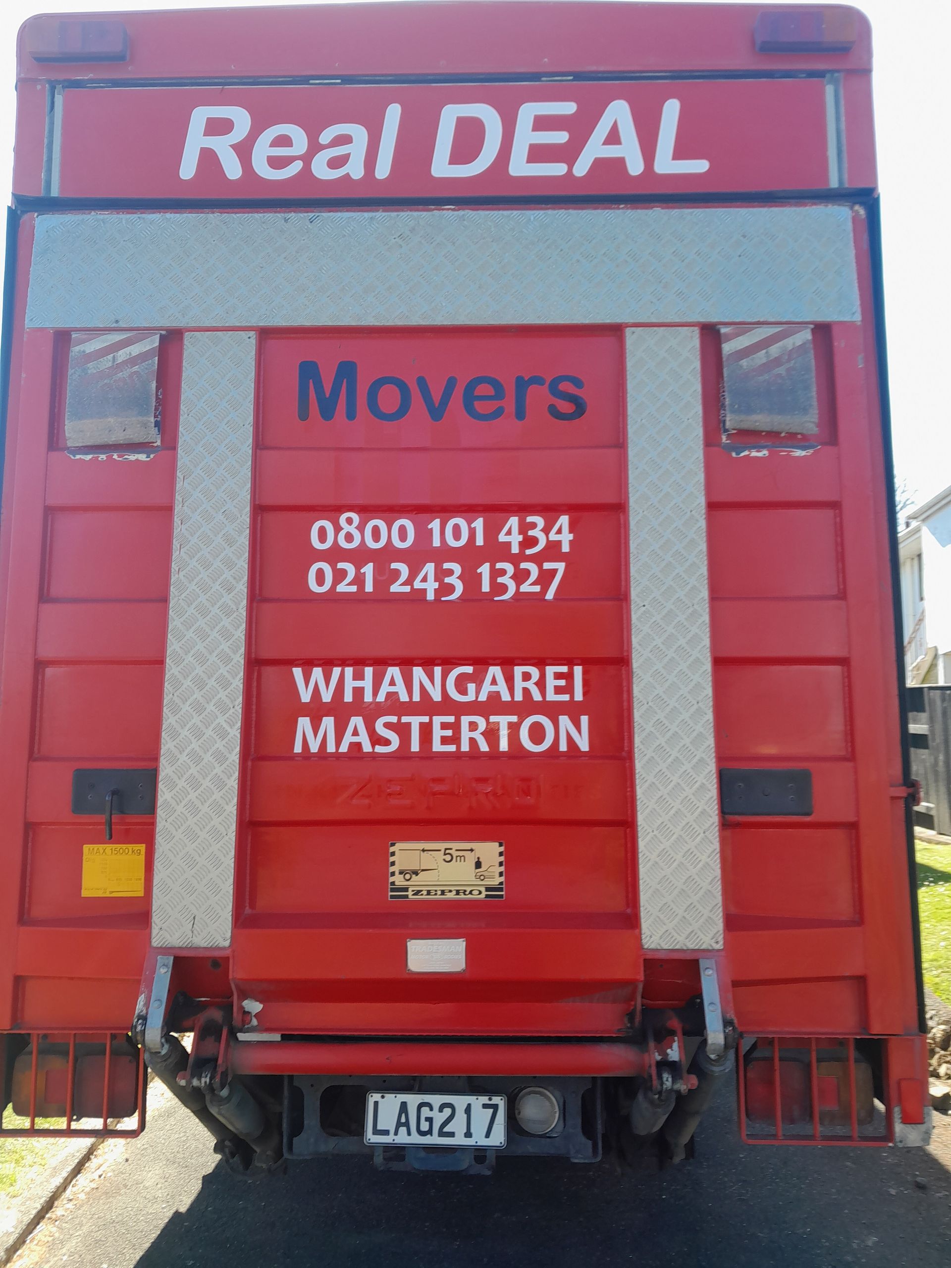 The back of red Real Deal Movers truck