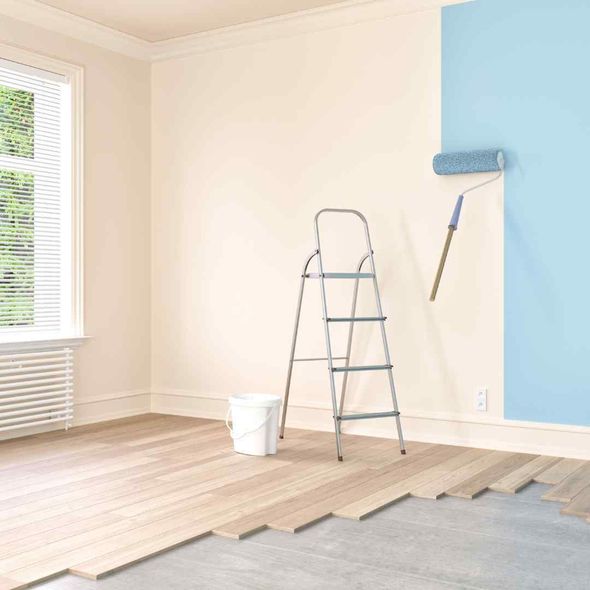 Empty room being painted, with ladder, bucket, and blue paint on one wall
