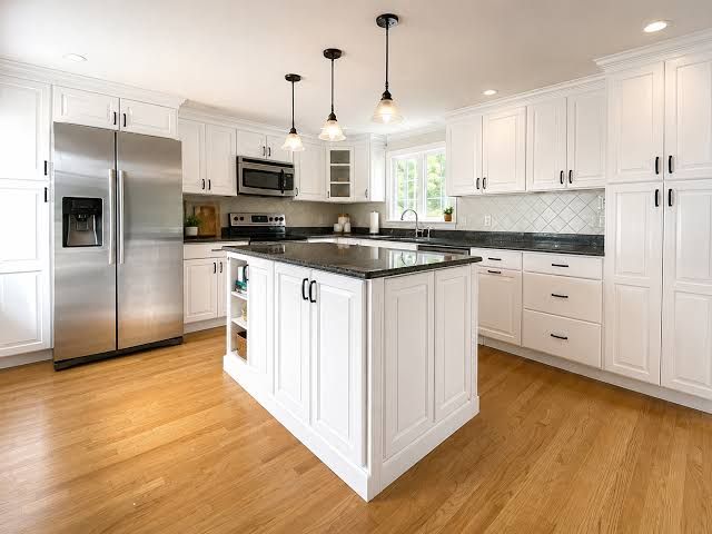 Bright modern white kitchen with stainless steel appliances and a black island countertop