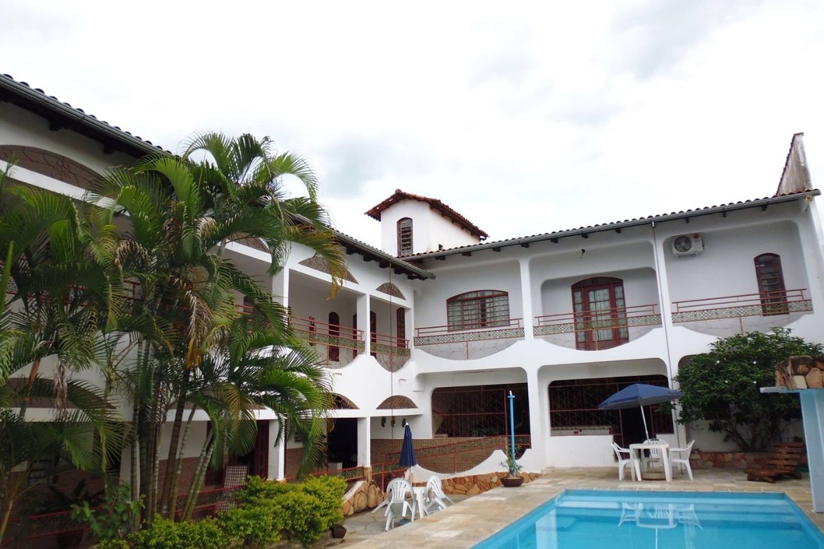 Uma grande casa branca com uma piscina na frente
