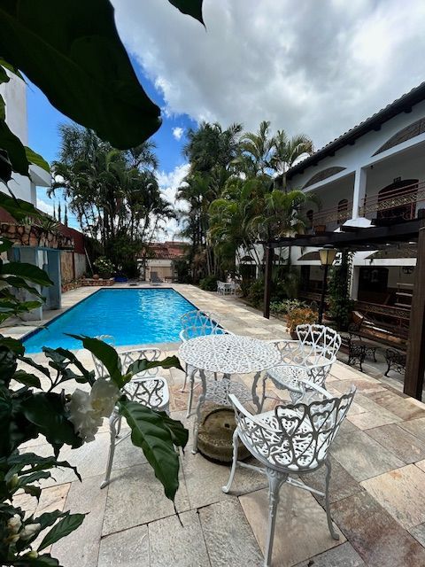 Uma piscina com uma mesa e cadeiras na frente dela