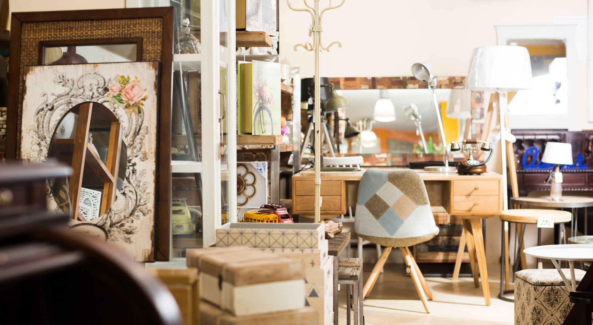 Man in a sunlit home office, standing at a desk surrounded by books, lamps, and framed art.