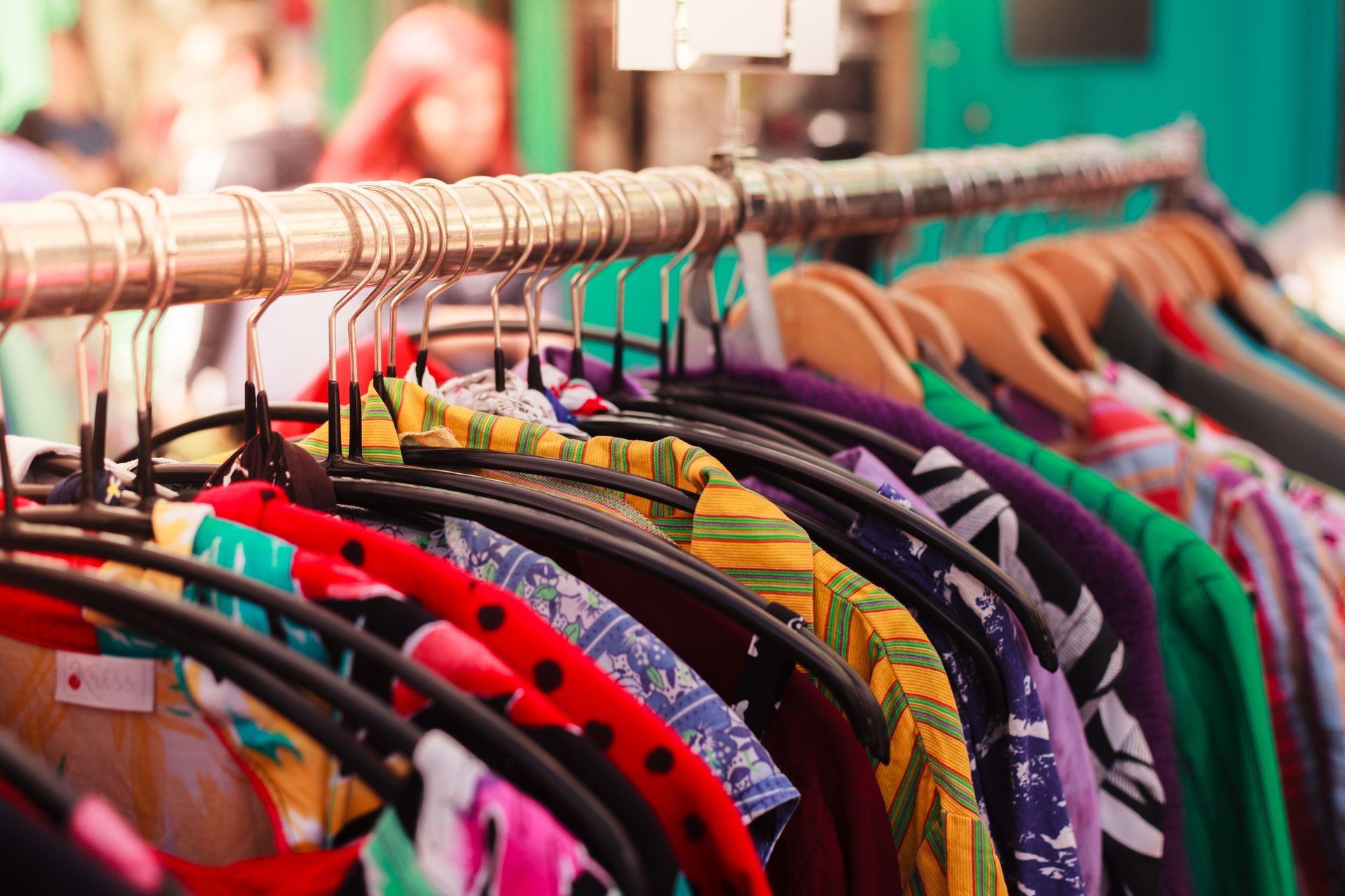 Clothing store display with jackets and jeans hanging on wooden racks in a boutique interior