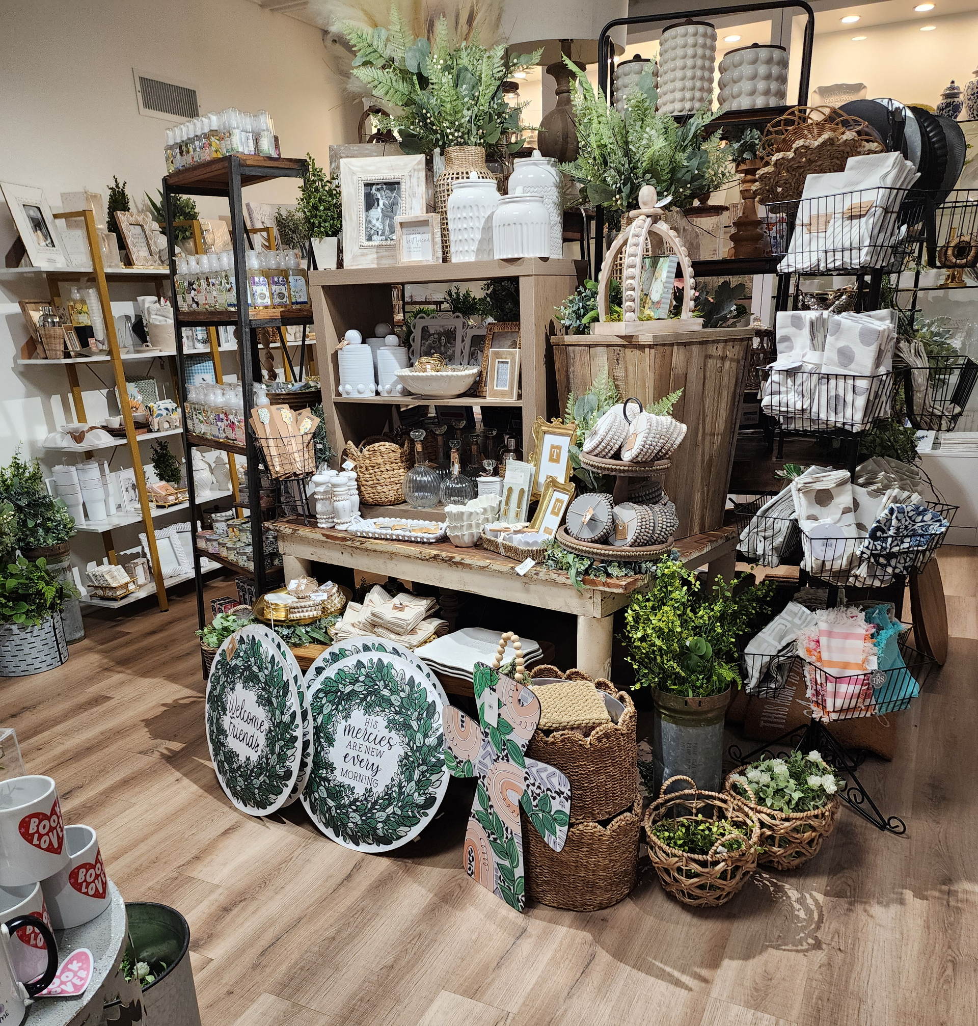 Decorative vases, framed prints, and accent objects on a shop shelf