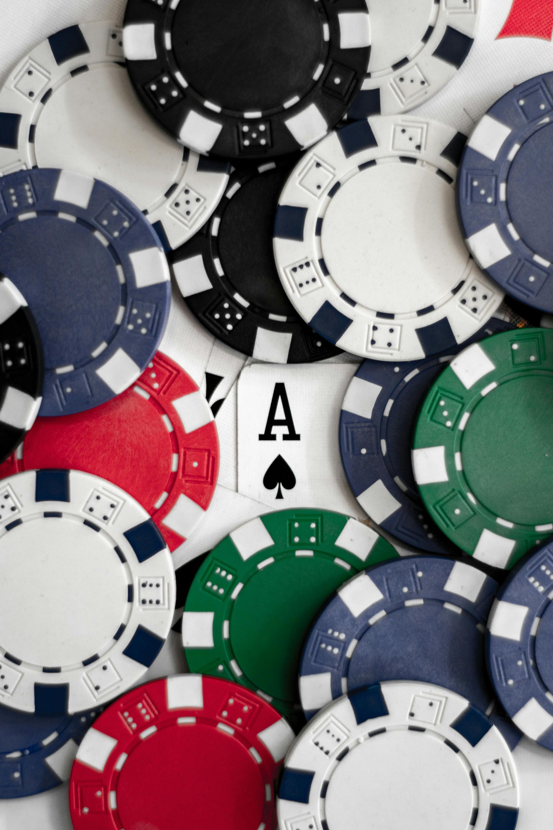 Poker chips in various colors surround an Ace of Spades card.