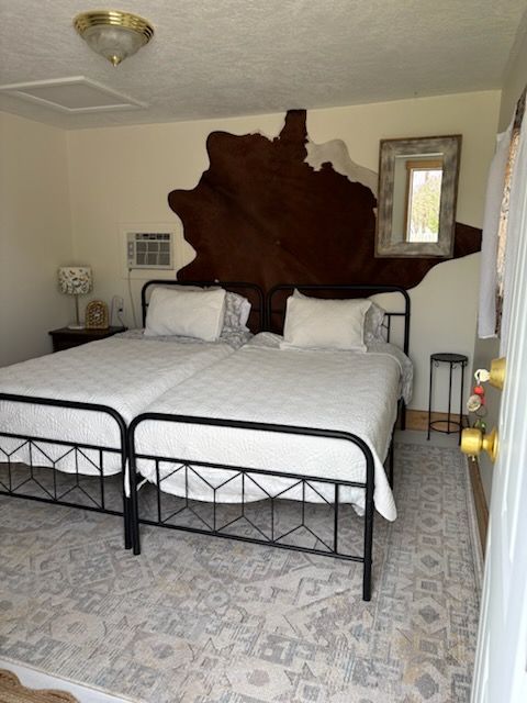A bedroom with two beds and a mirror on the wall