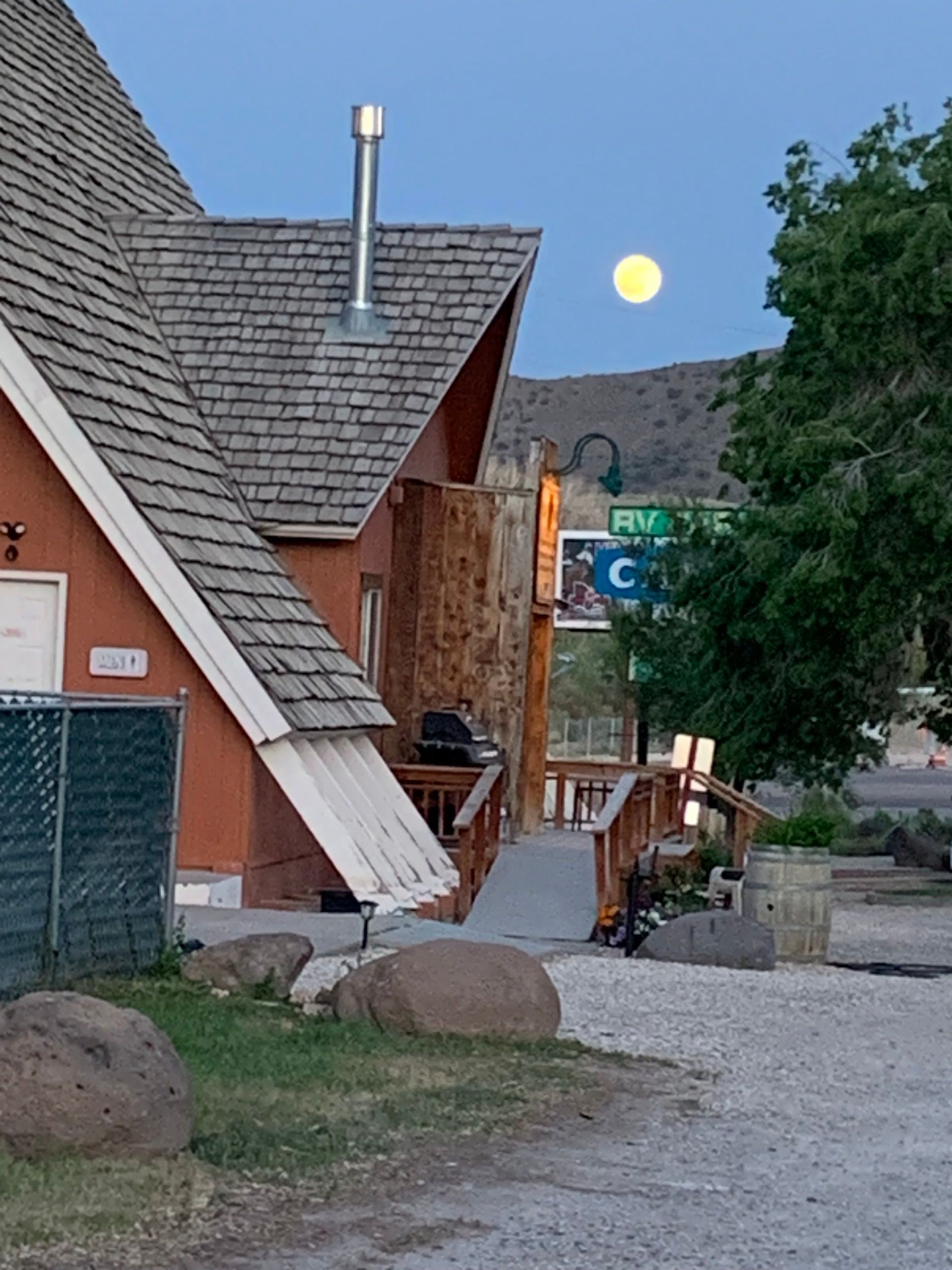 A house with a full moon in the background and a sign that says pm on it