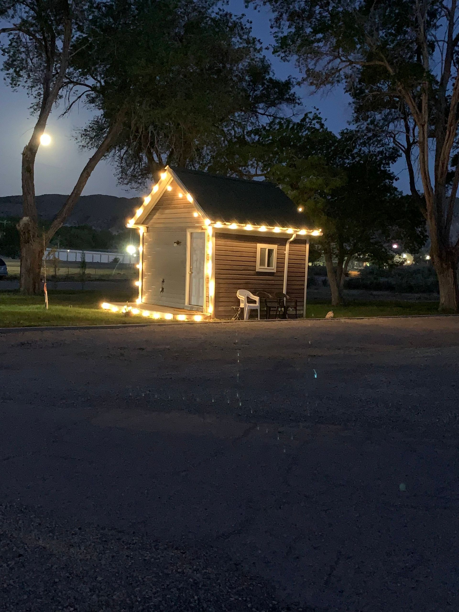 A small house with lights on it is lit up at night.