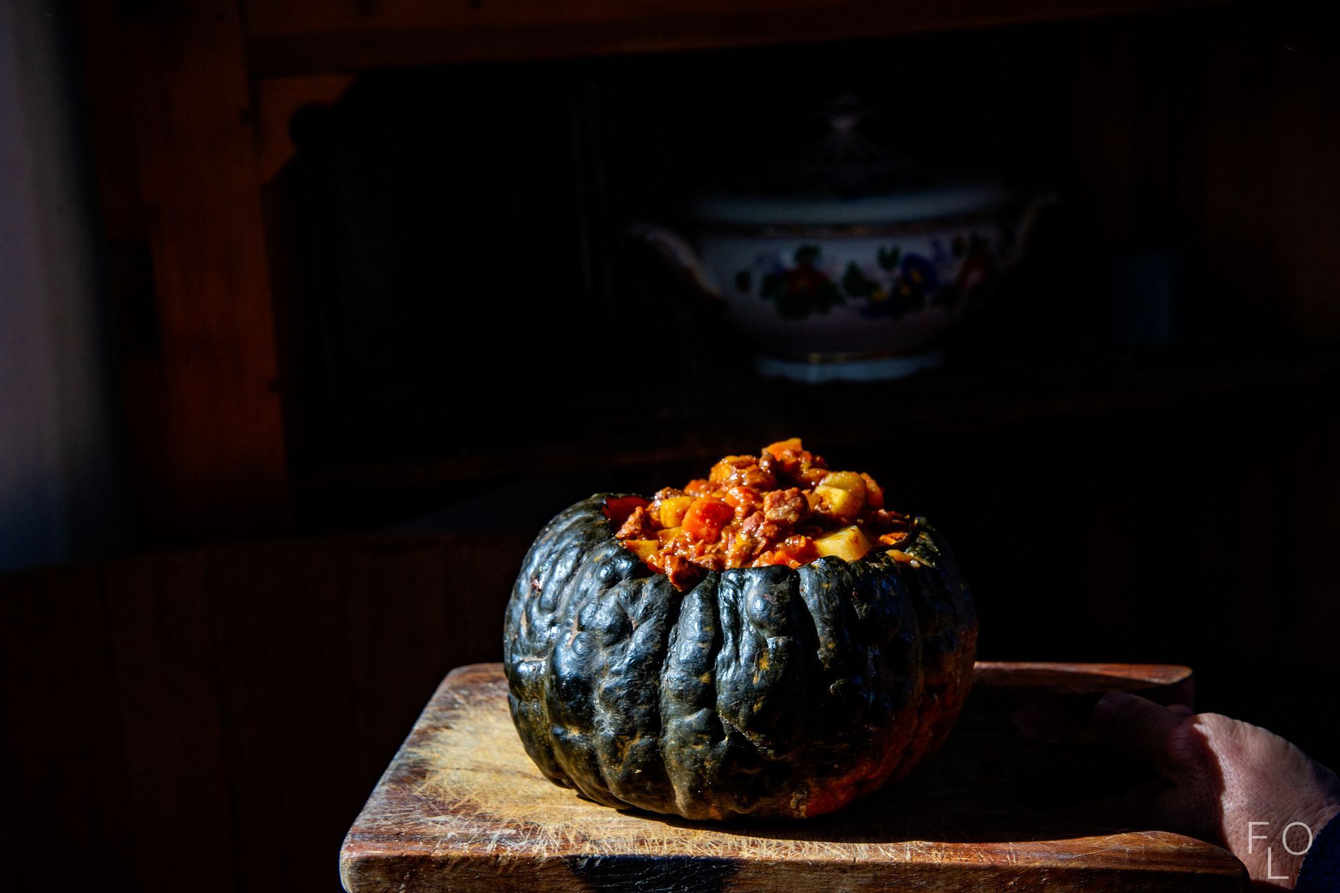 Roasted stuffed squash on a wooden board in low light