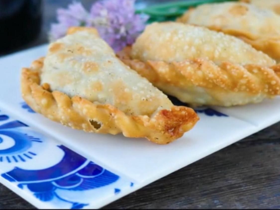 Fried dumplings on a blue-and-white plate, with crispy golden edges on a table