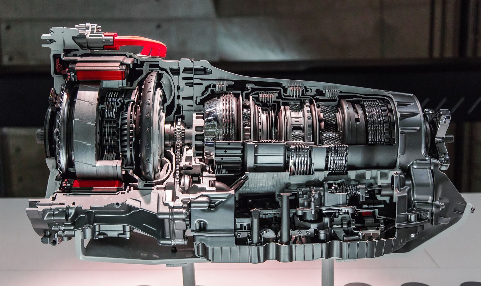 Cutaway of a modern jet engine with exposed metallic components and red piping