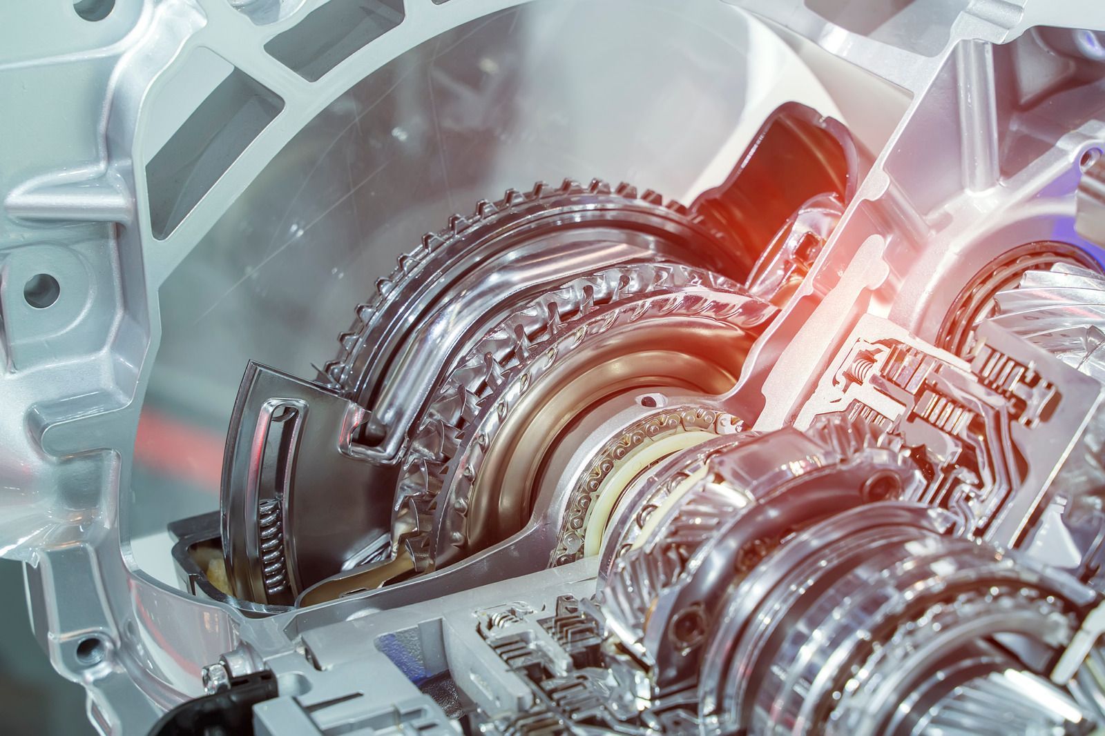 Close-up of a shiny mechanical gearbox with gears and metal components glowing red