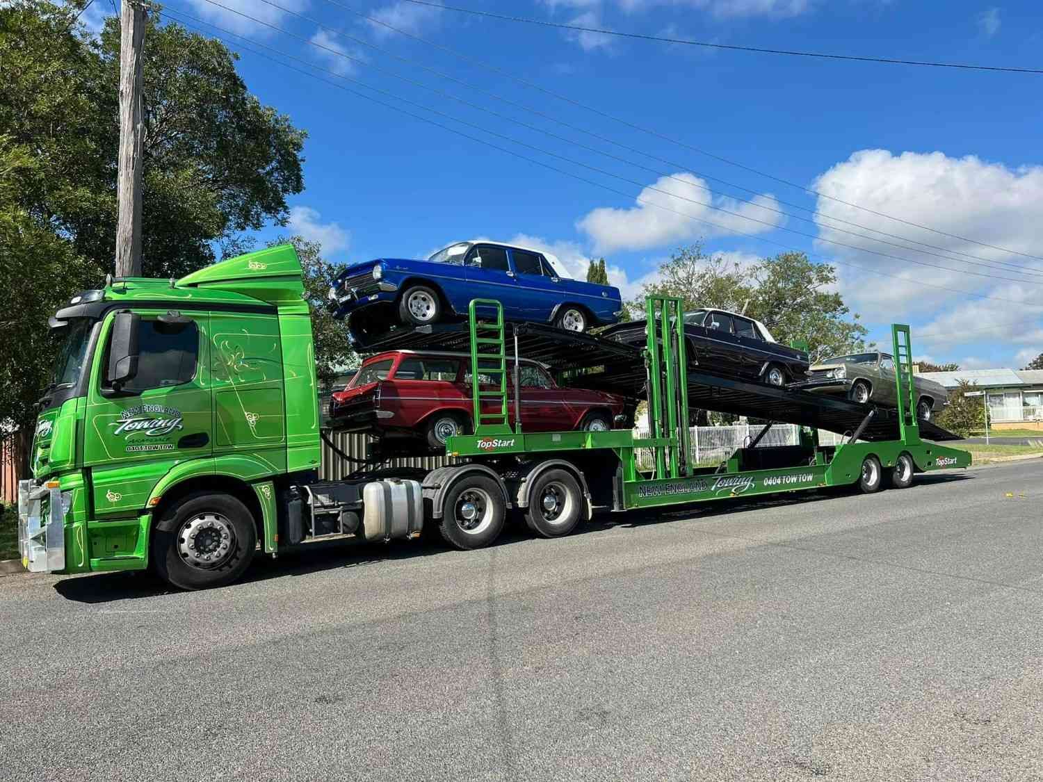 A Green Car Carrier Truck Transporting Multiple Classic Cars — New England Towing in Warialda, NSW