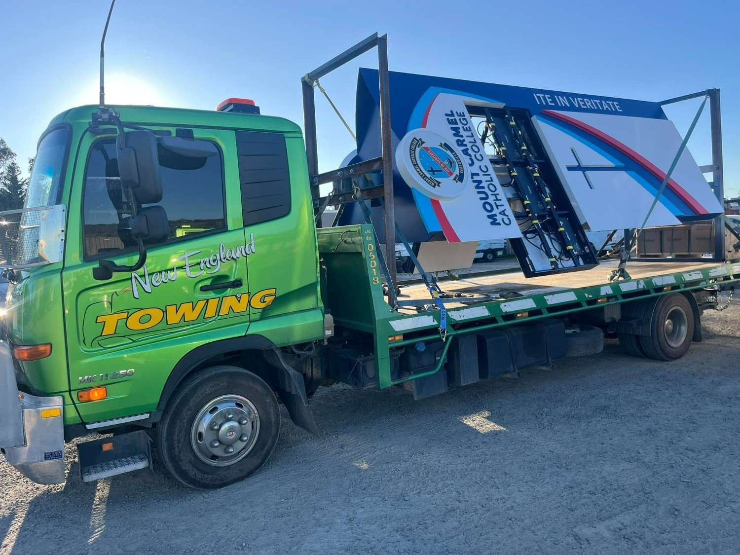 Green Tow Truck Transporting a Large Sign — New England Towing in Guyra, NSW
