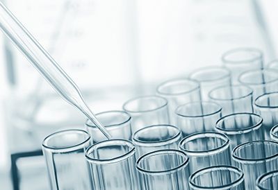 A pipette is being used to pour liquid into a row of test tubes.