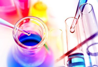 A close up of a bottle with a pipette in it and test tubes.
