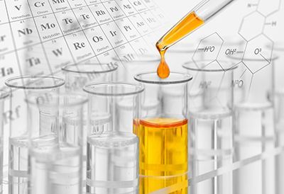 A drop of liquid is being poured into a test tube.