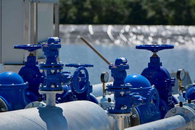 Blue industrial valves and pipes on a metal pipeline in an outdoor facility