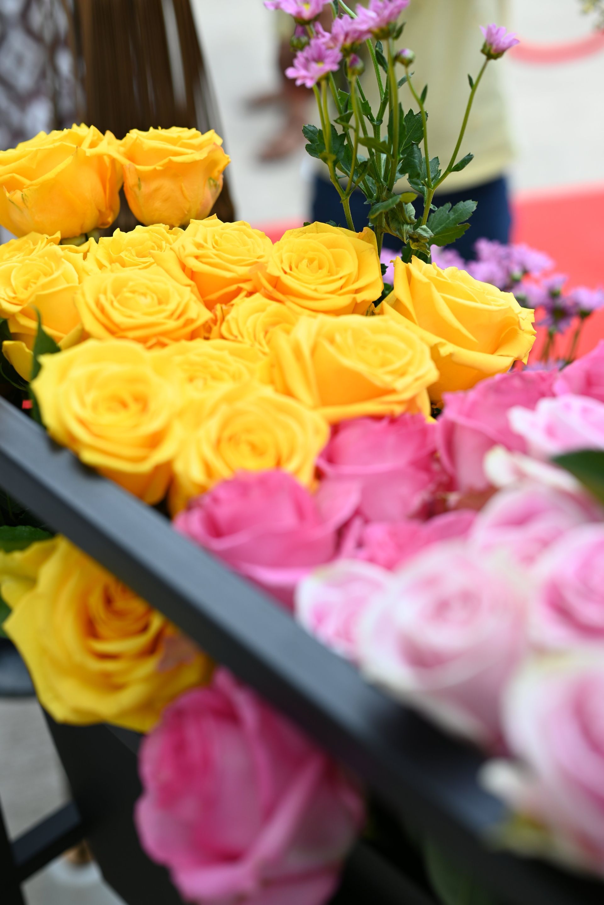 Bright yellow and pink roses arranged in a flower display