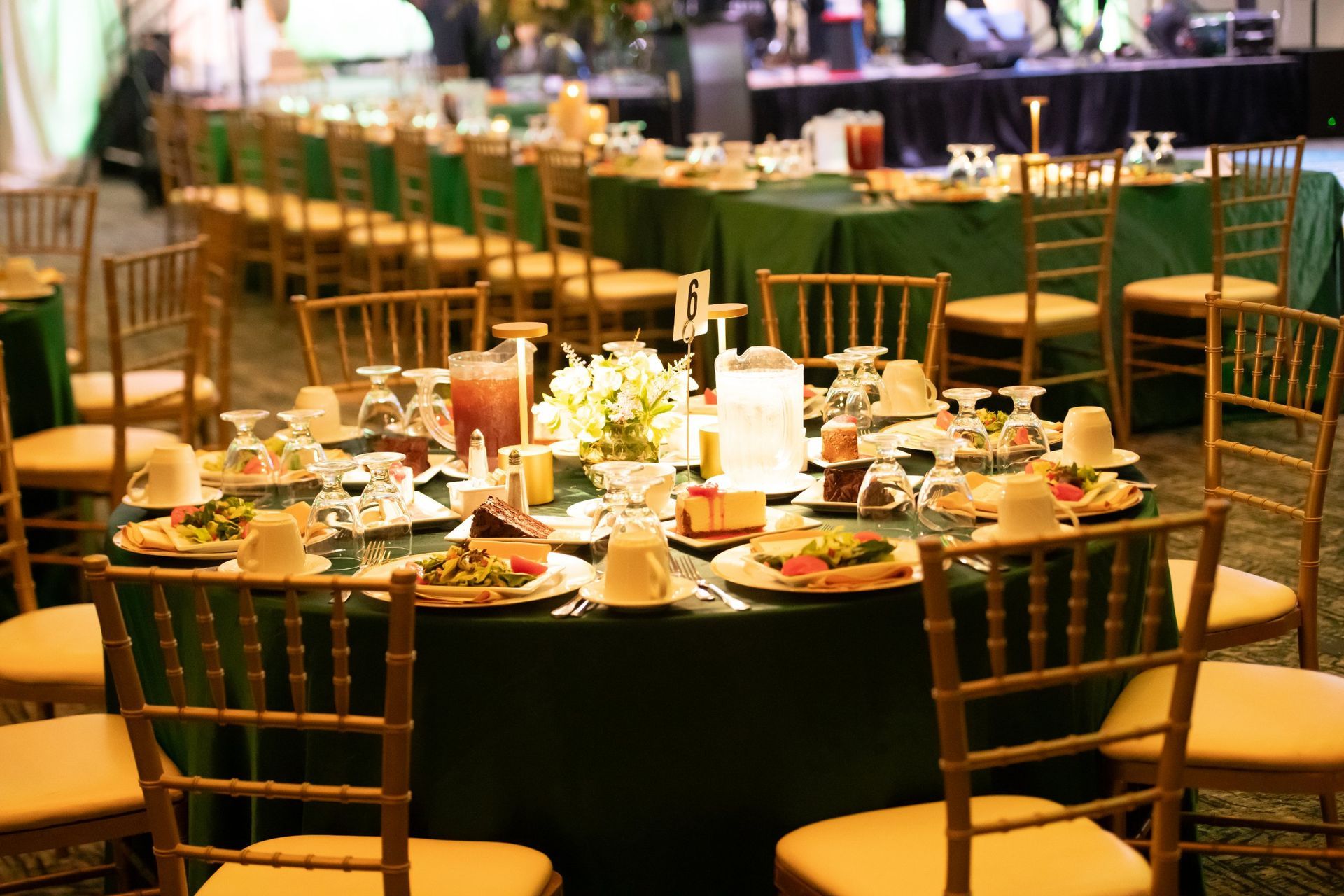 Round banquet tables set for a formal event in a warmly lit dining room
