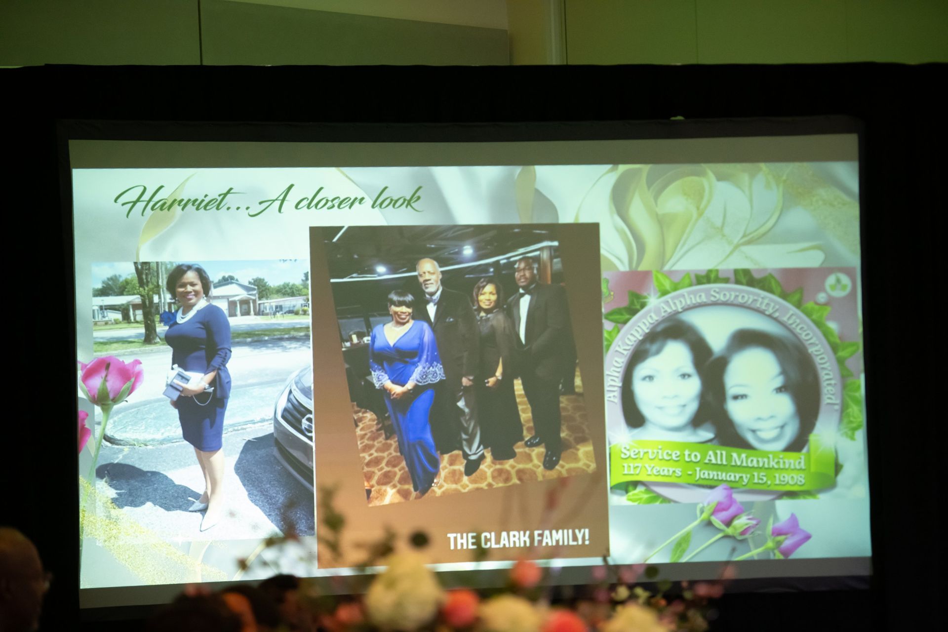 Collage of wedding photos on a projected slide with floral background and heart-framed portraits