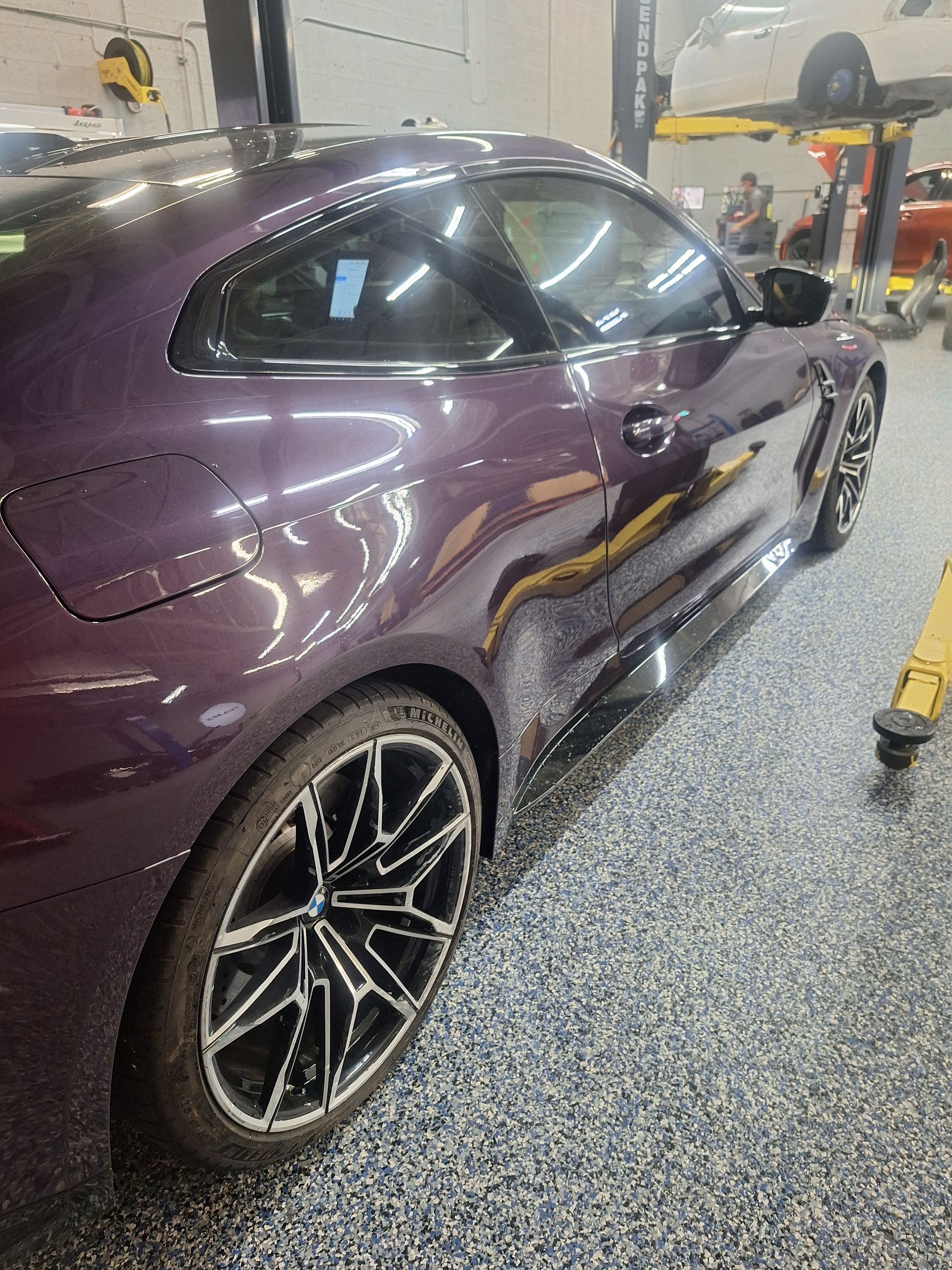 Purple sports coupe in a garage, side view with black rims and reflections on the glossy paint | Temis Motorsports