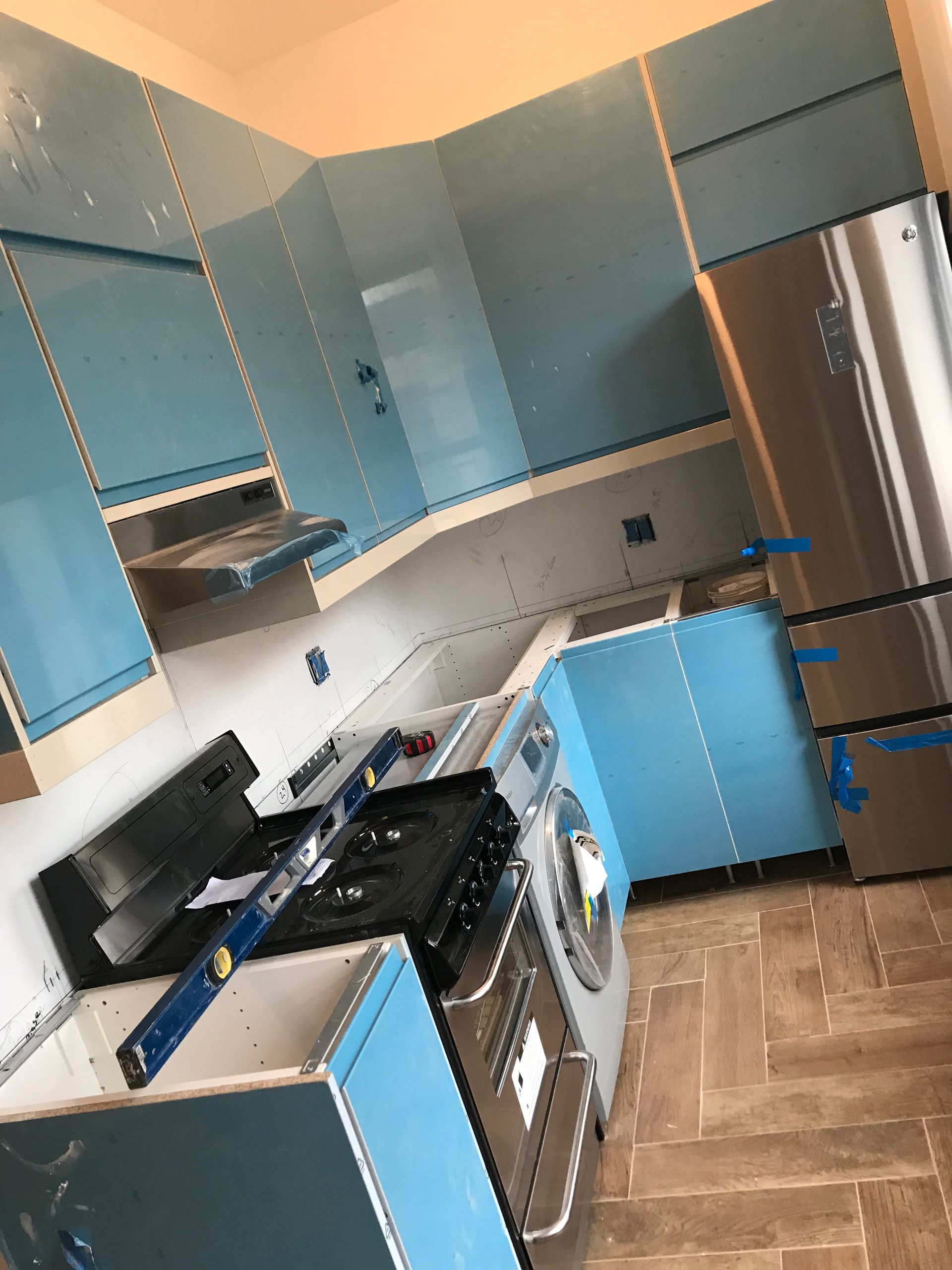 Blue and silver kitchen with gas stove, oven, cabinets, and wood-pattern floor