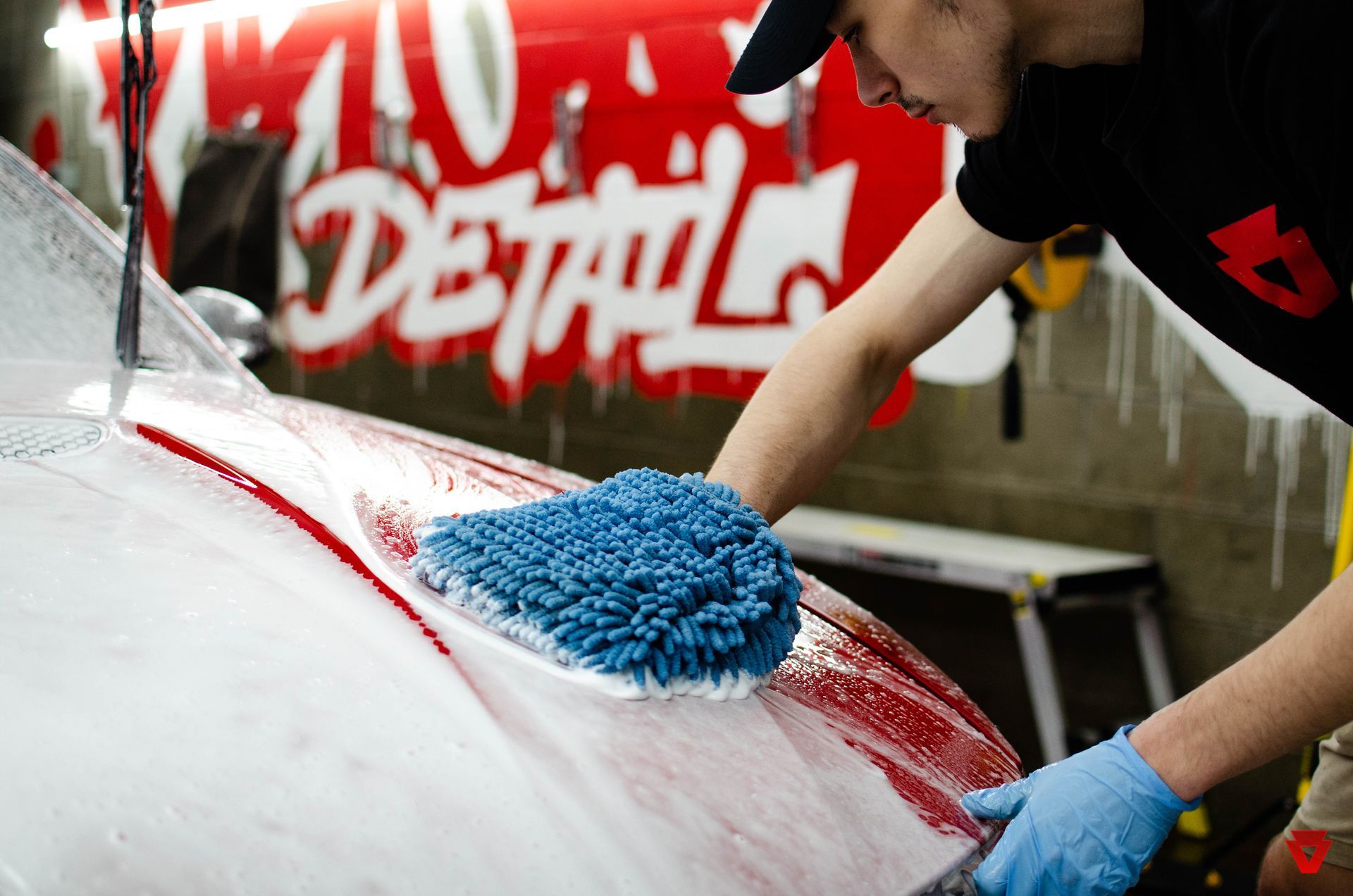 a man is cleaning a car with a blue cloth .
