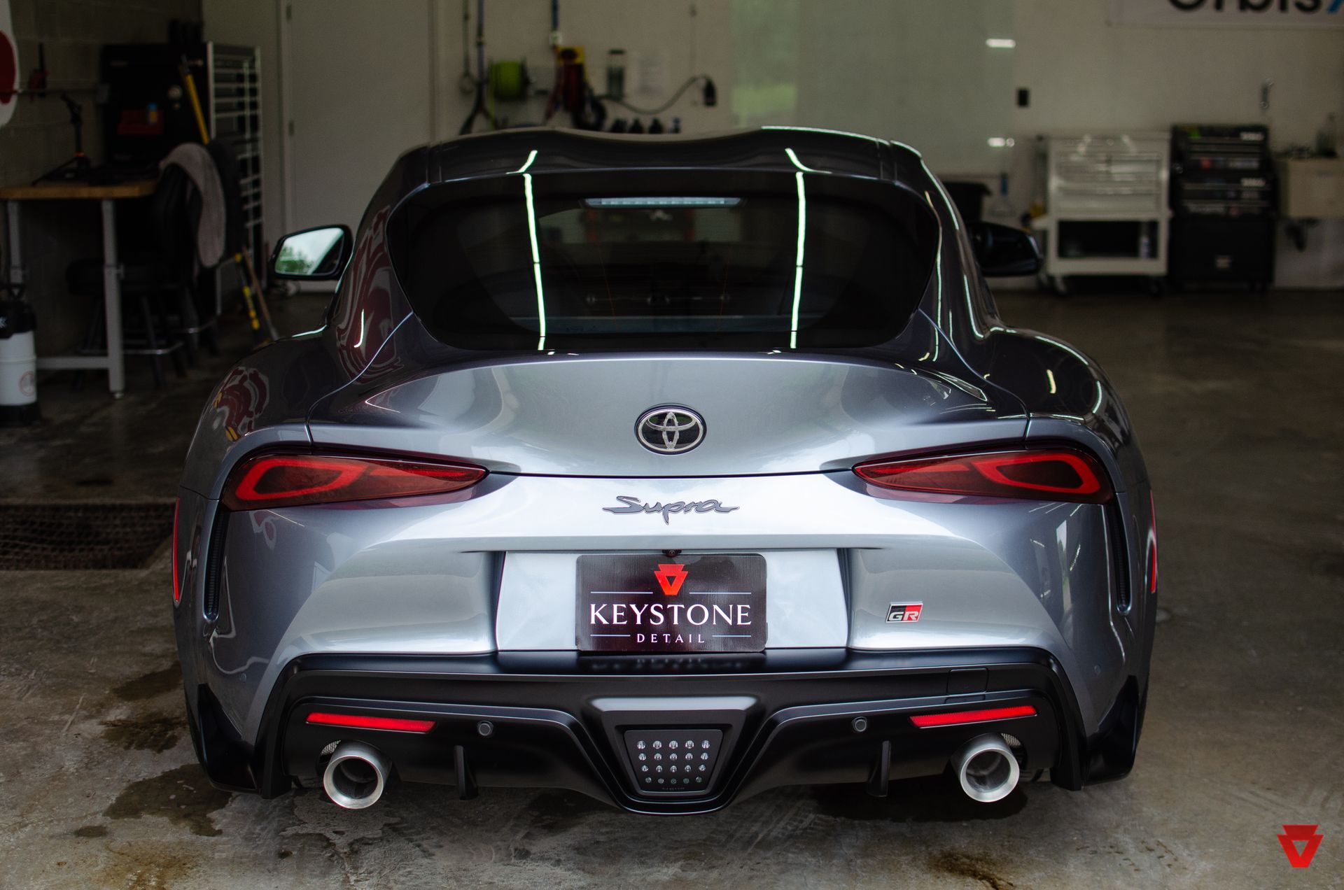 Rear view of a silver Toyota sports coupe with red accents parked in a garage