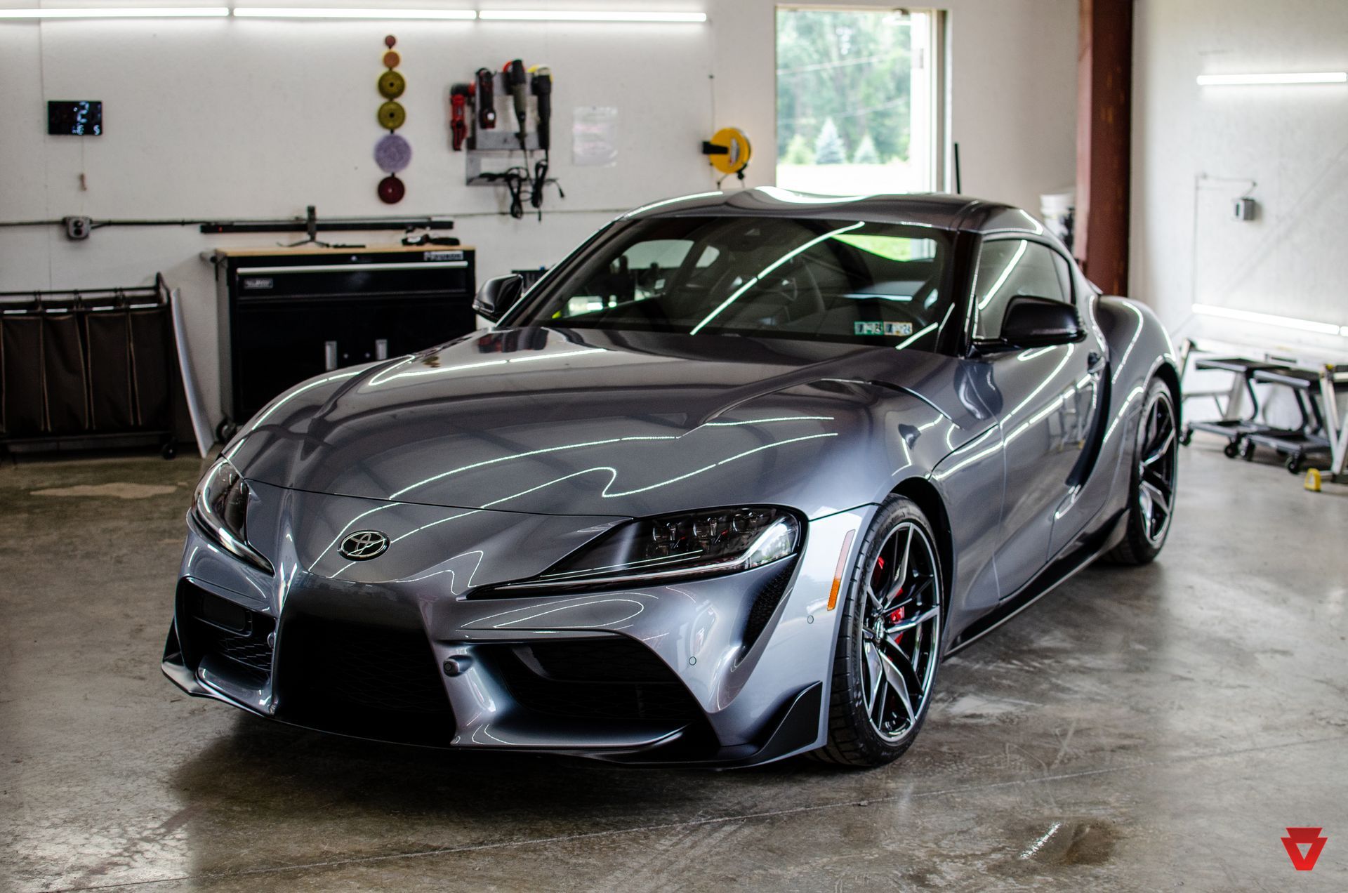 Silver sports car parked in a garage, front three-quarter view.