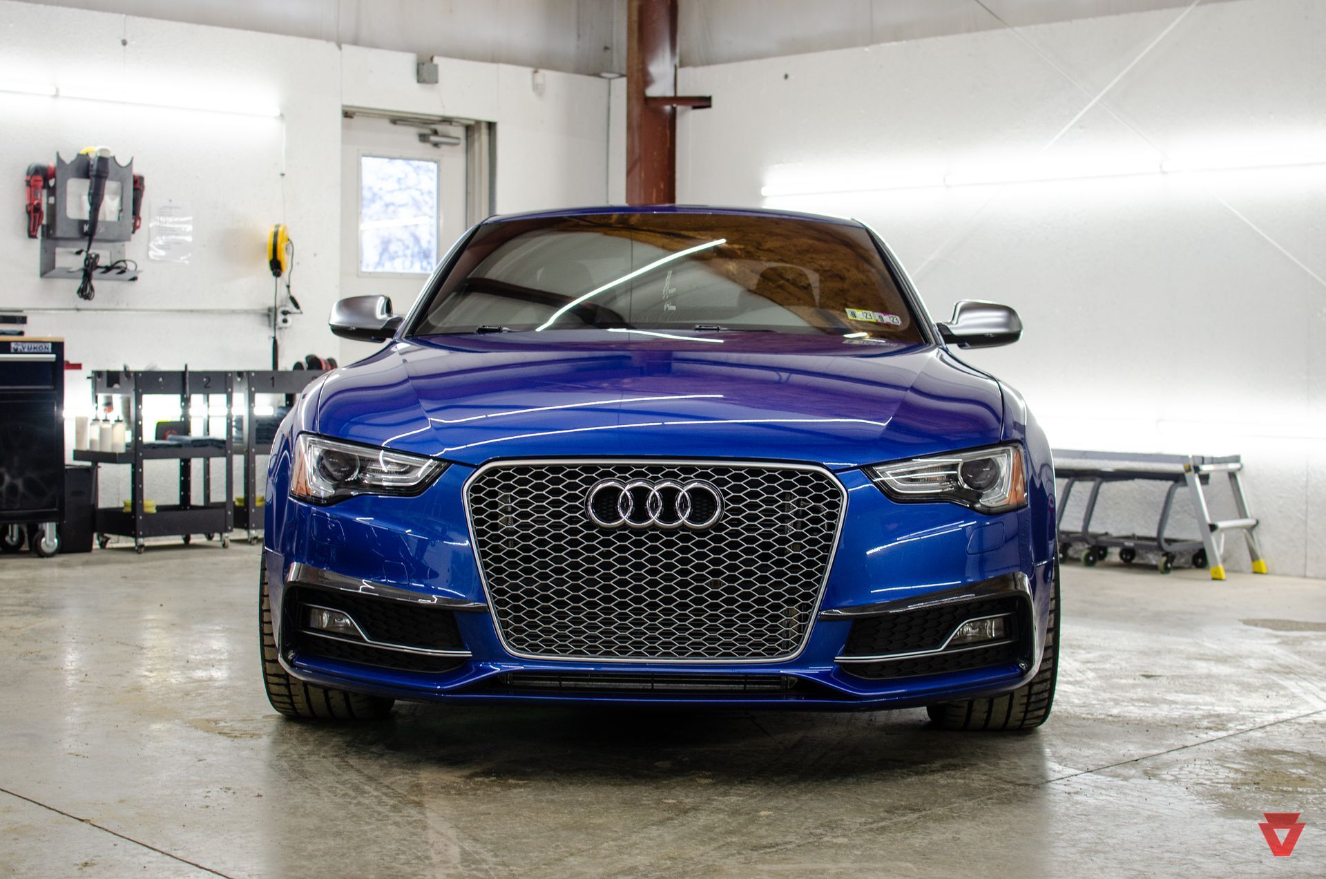 a blue audi a5 is parked in a garage .