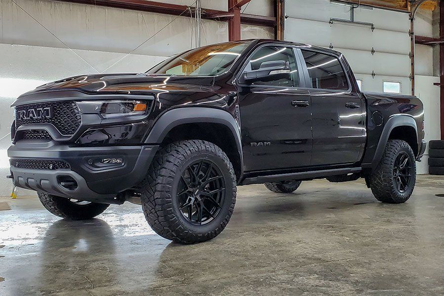 a black dodge ram truck is parked in a garage .
