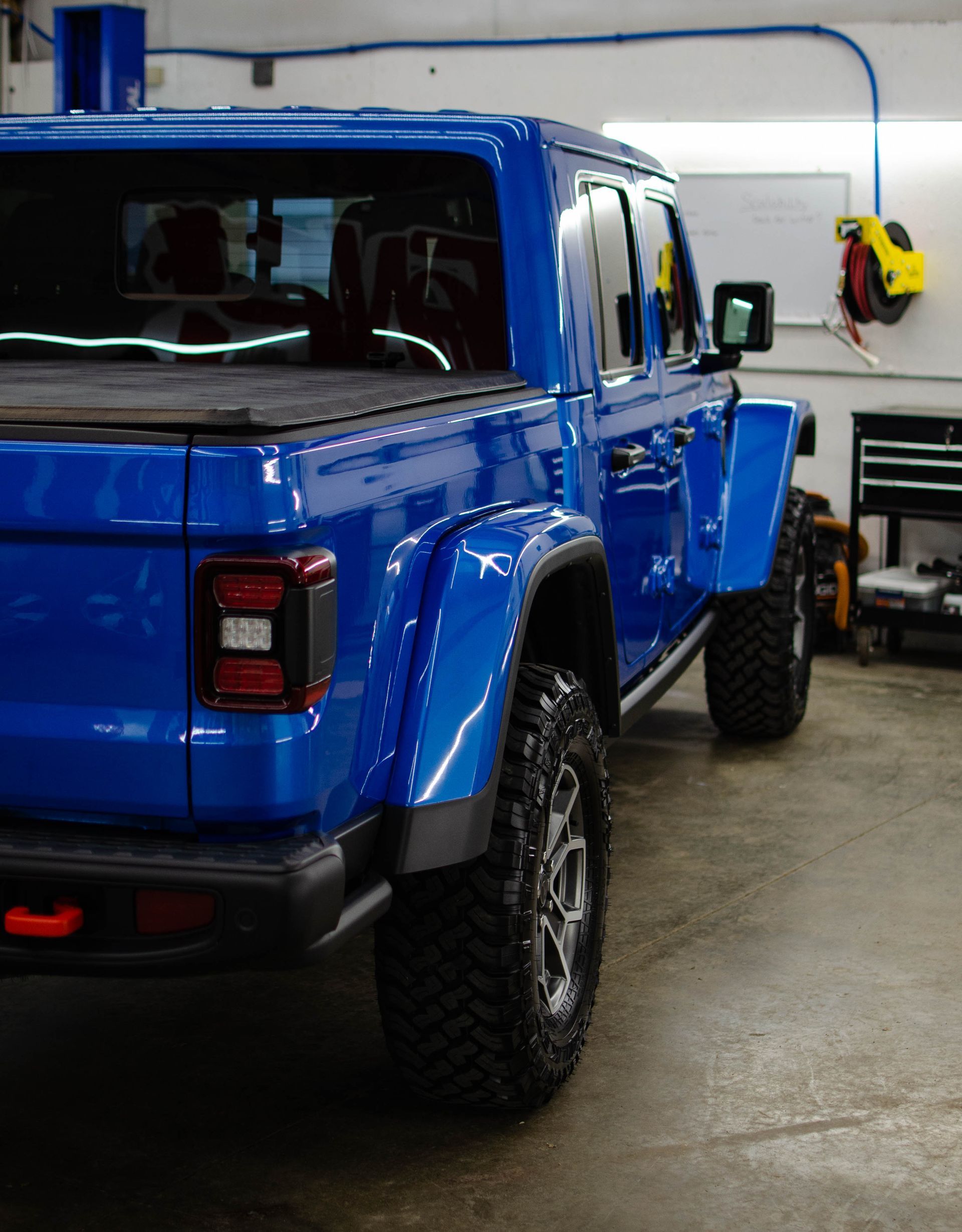 Blue pickup truck parked inside a garage.