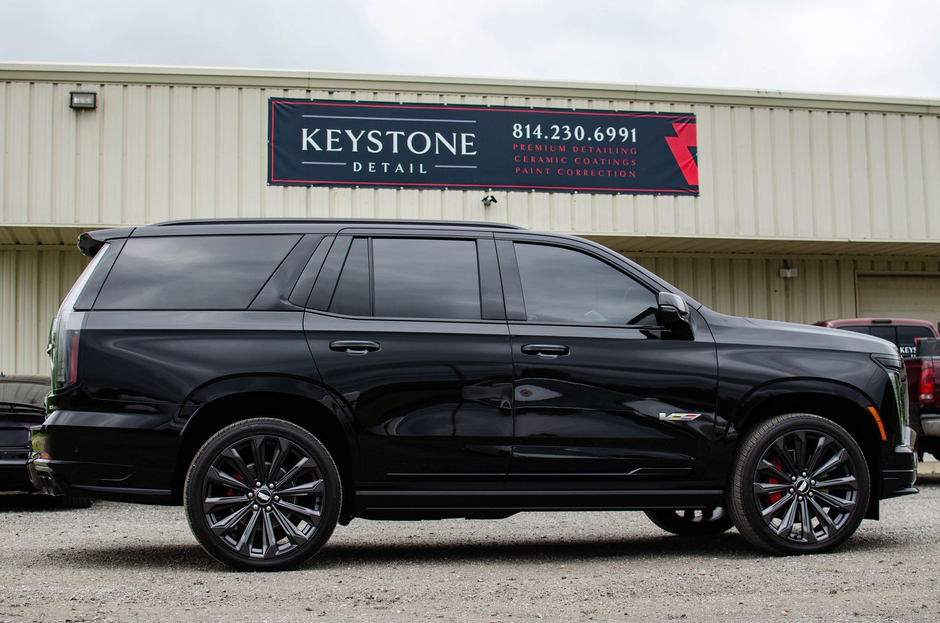 Black SUV parked in front of a Keystone sign on a beige building