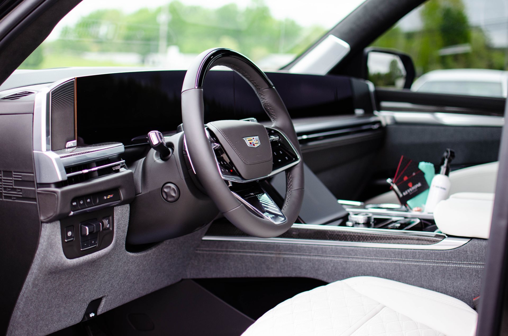 Modern car interior with steering wheel, dashboard, and white seats