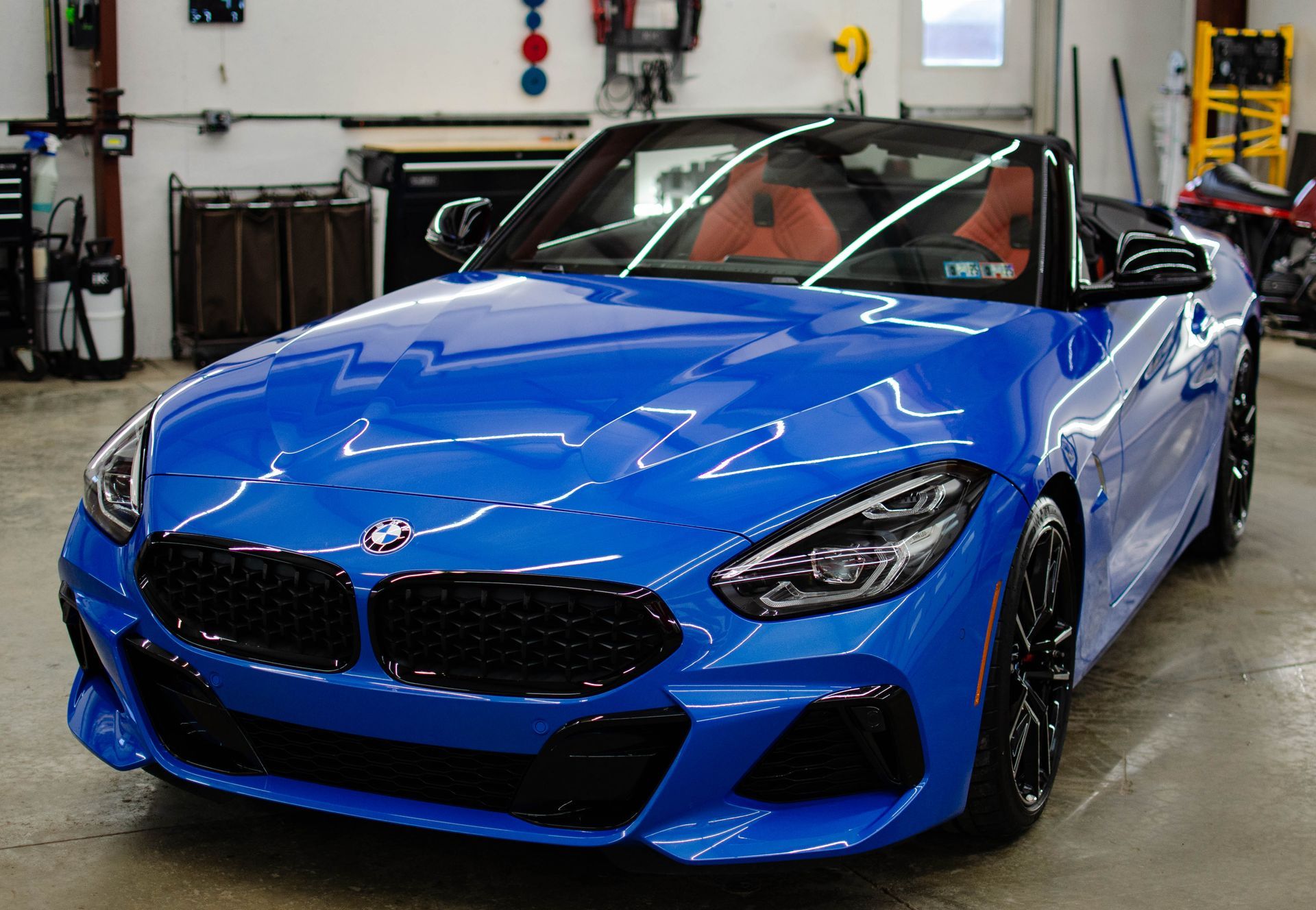 Blue BMW convertible parked in a workshop garage