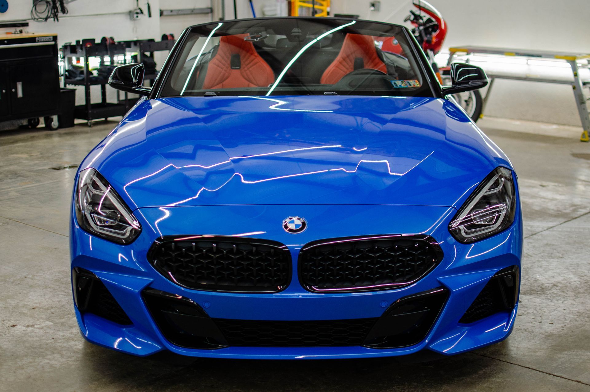 Blue BMW sports car in a garage, viewed from the front.