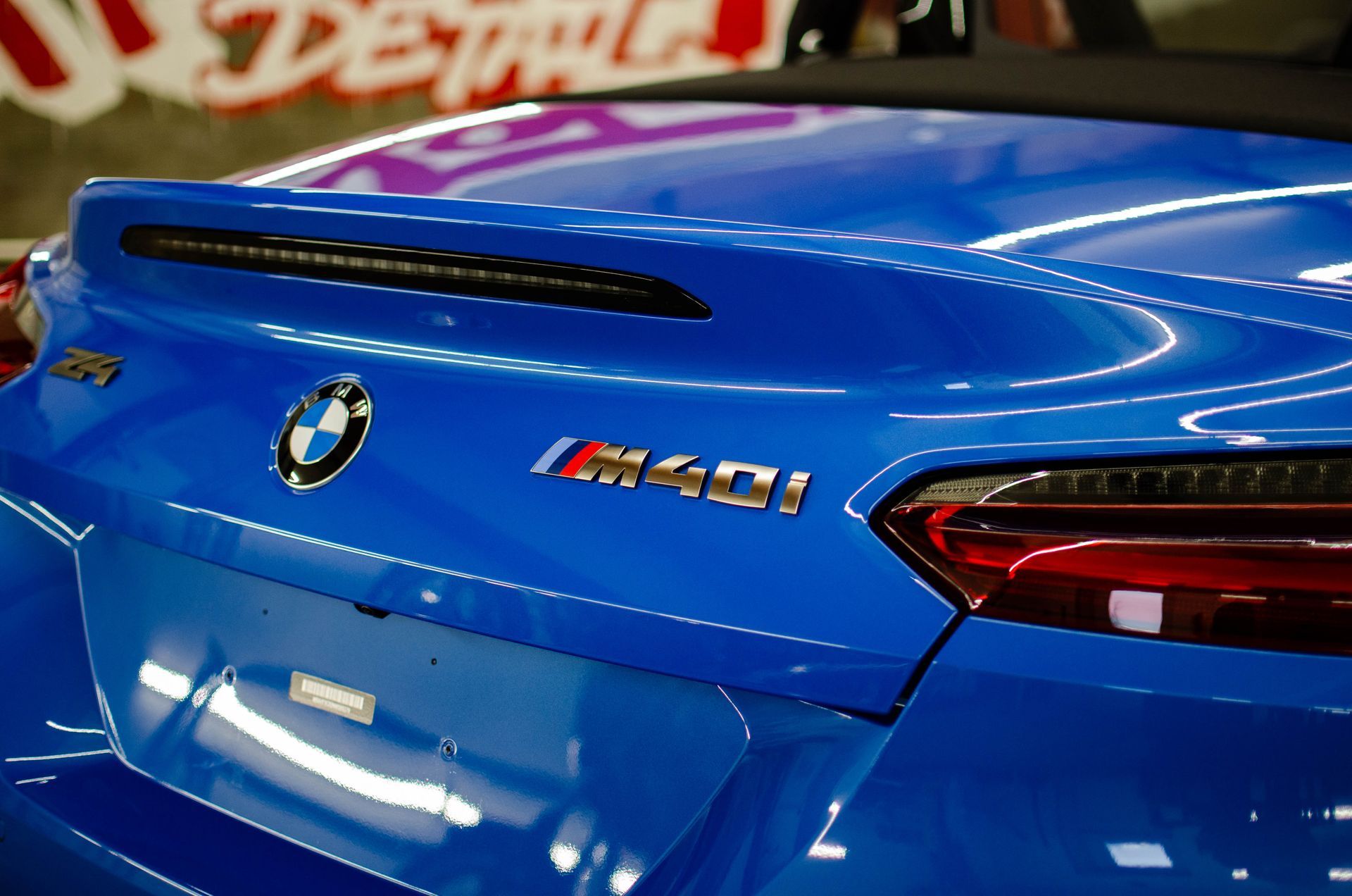 Rear view of a blue BMW M8 badge and taillight on display