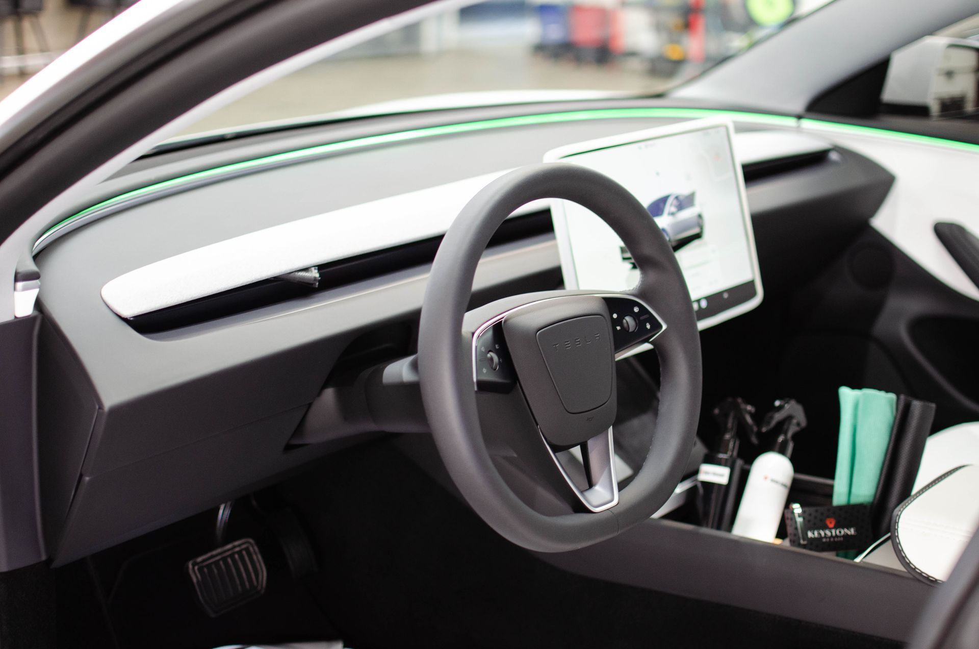 Modern car interior with steering wheel, dashboard display, and center console storage