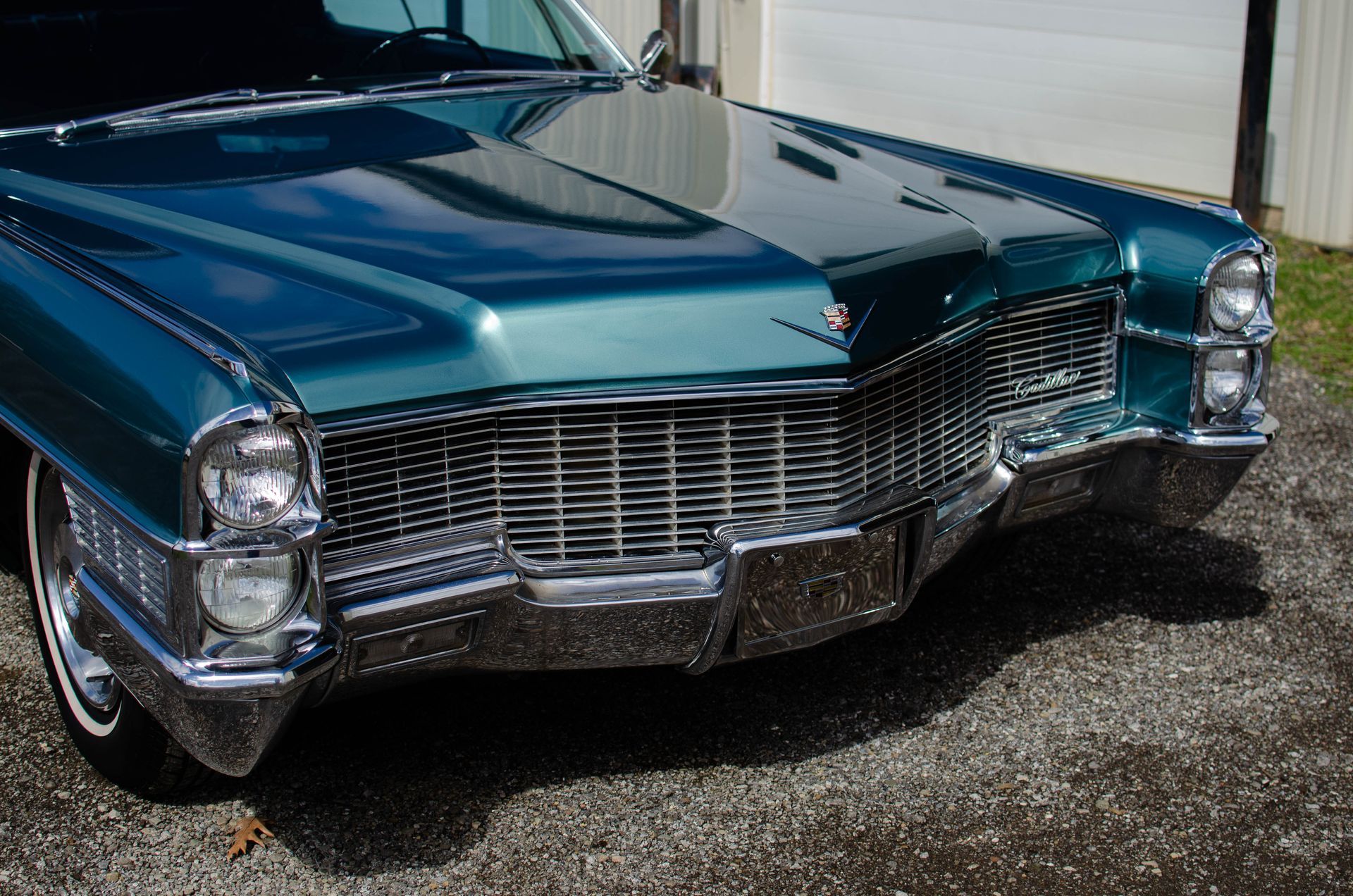 Front view of a teal vintage Cadillac parked on pavement