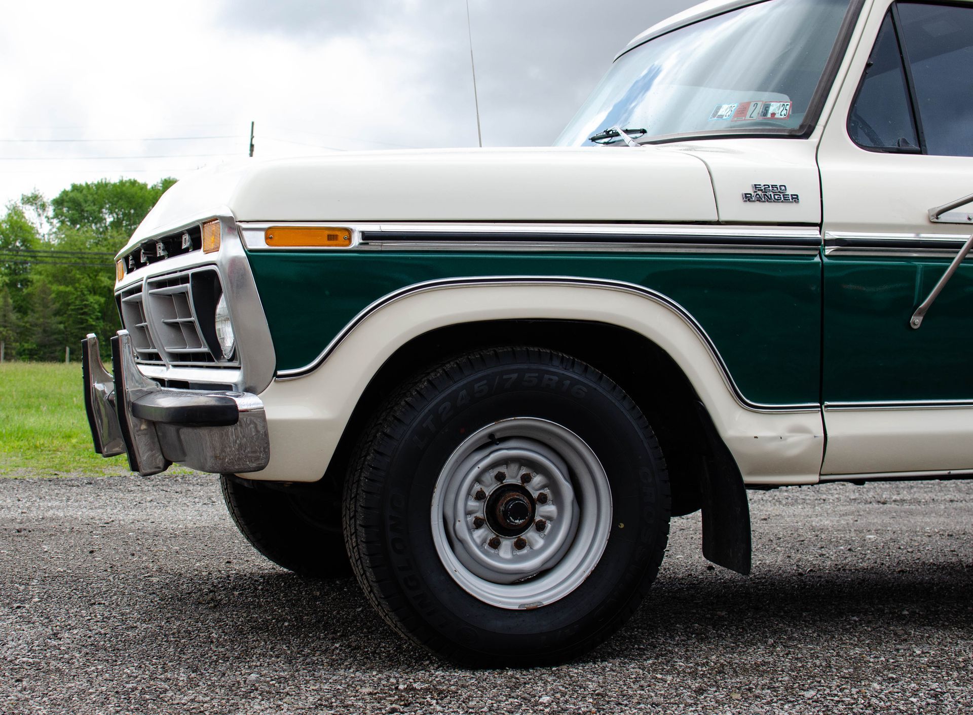 Vintage green-and-cream pickup truck parked on gravel outdoors