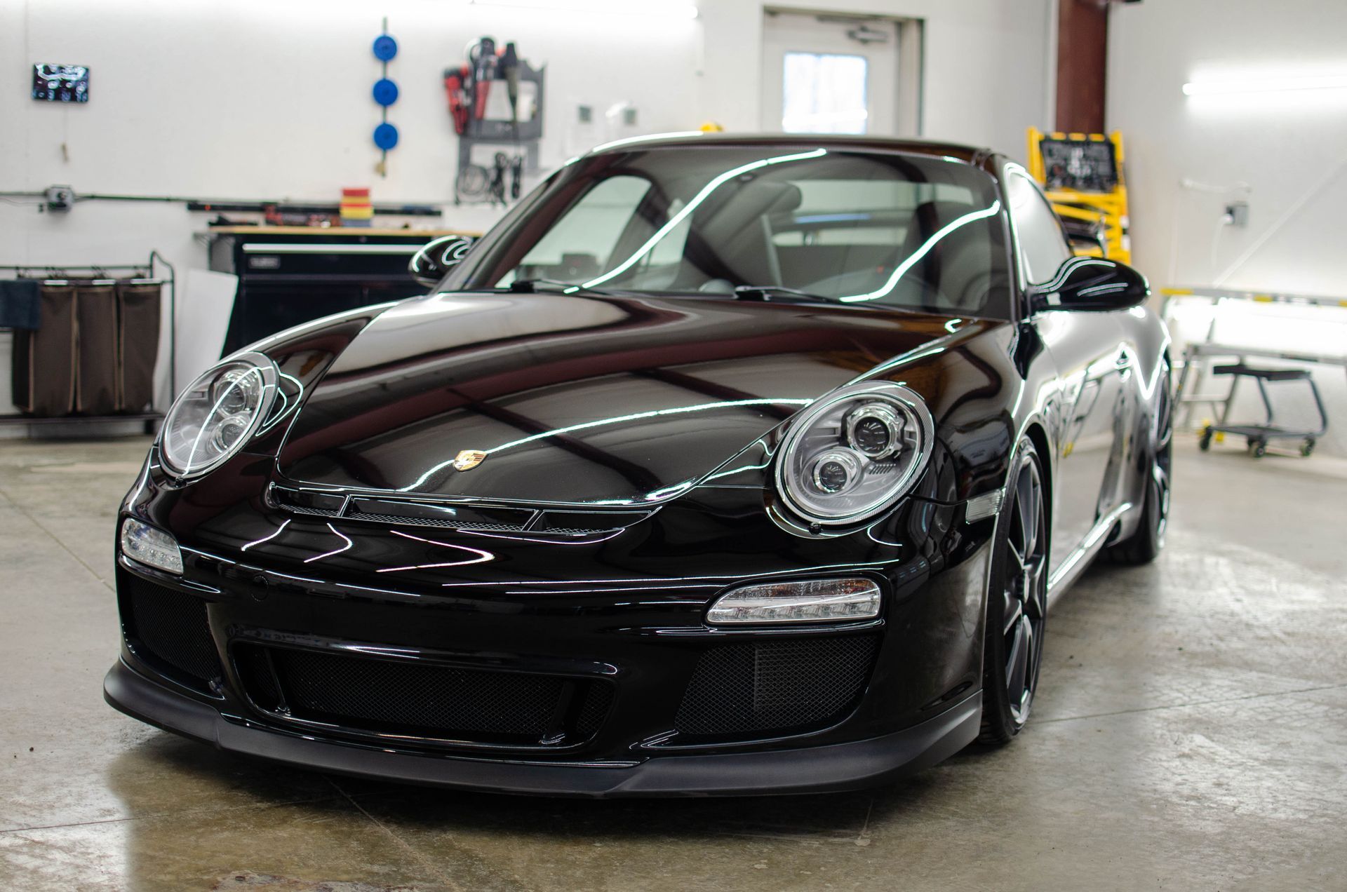 Black sports car in a garage, viewed from the front.