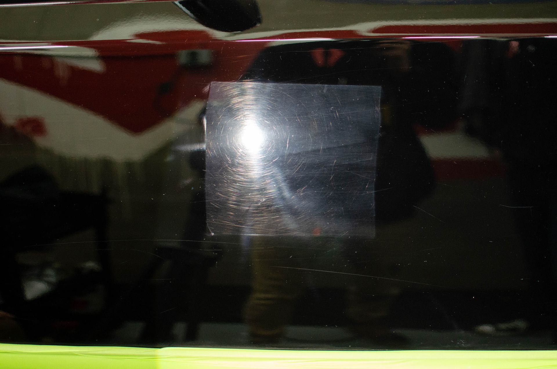 Dark reflective window with a bright glare and green strip along the bottom