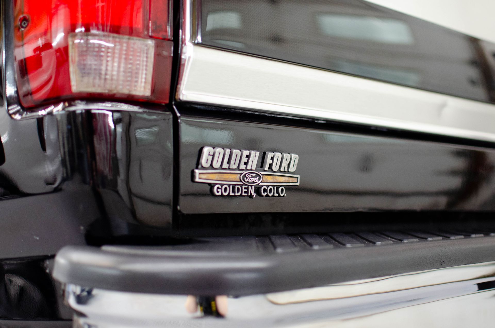 Close-up of a black Ford Golden Circle SUV rear badge and taillight