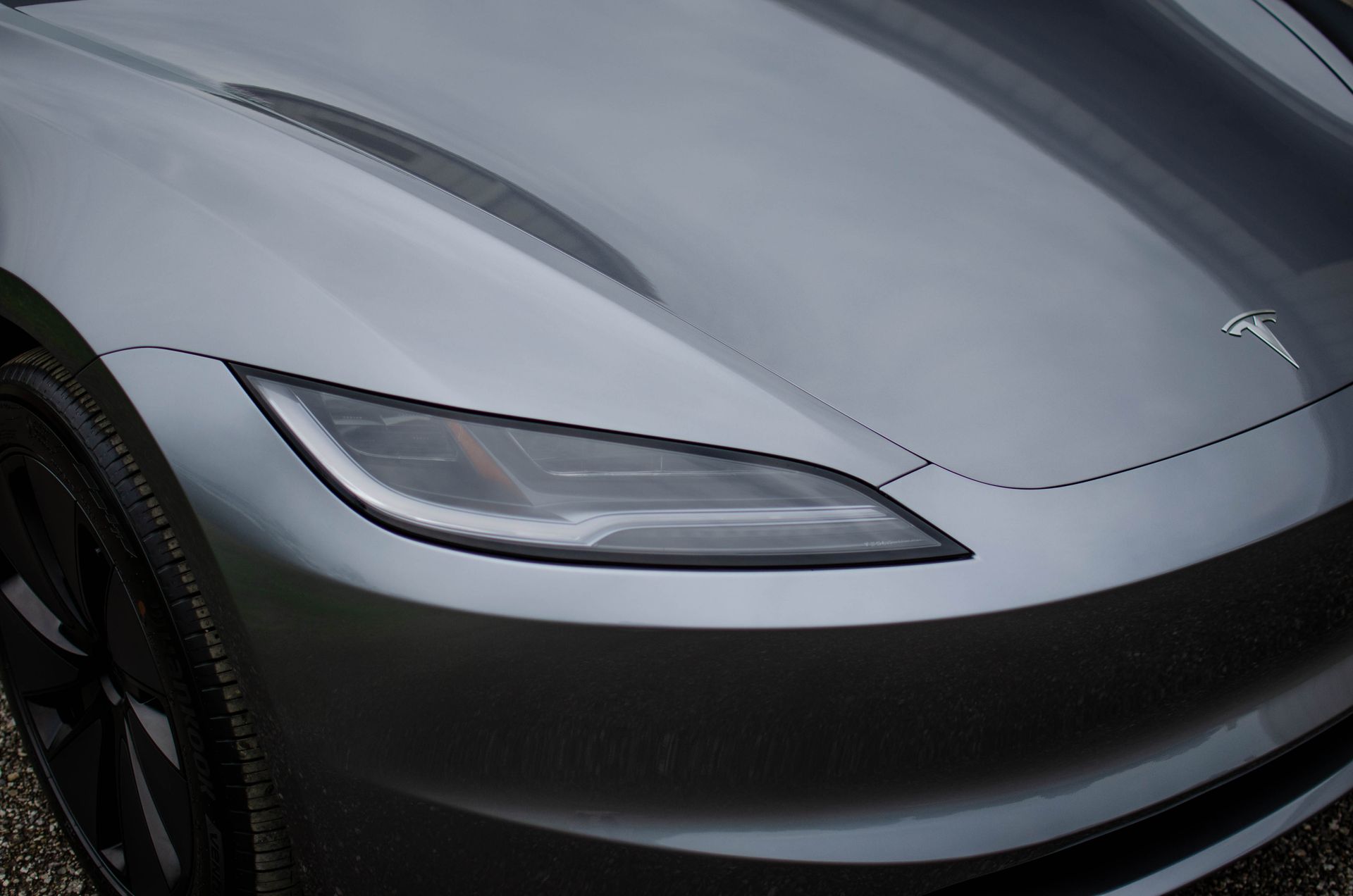 Close-up of a silver sports car’s front hood and headlight
